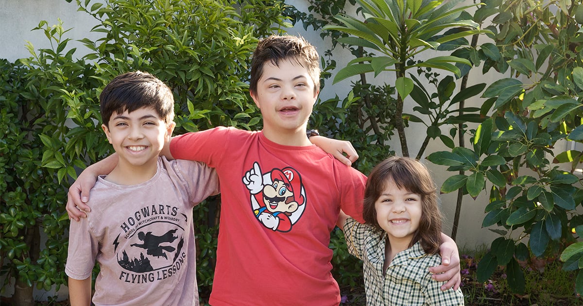 three children smiling, one with down syndrome