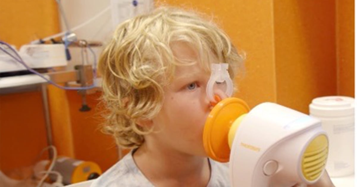 child breathing into a respiratory device