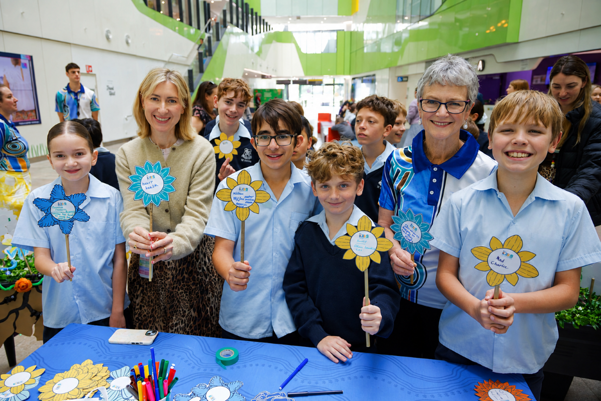 children holding up flowers they've written on